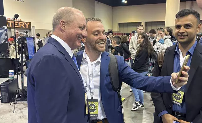 Berkshire Hathaway shareholders line up to take selfies with Greg Abel Friday, May 3, 2024, in Omaha, Neb. Abel will one day replace Warren Buffett as CEO. (AP Photo/Josh Funk)