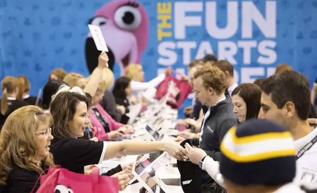 Valerie Deichert of Omaha, left, assists shareholders with their purchases from the Oriental Trading booth during the Berkshire Hathaway annual meeting on Saturday, May 4, 2024, in Omaha, Neb. (AP Photo/Rebecca S. Gratz)
