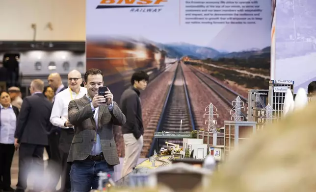 Bart Macdonald of New York City takes photos of the BNSF Railway model train display during the Berkshire Hathaway annual meeting on Saturday, May 4, 2024, in Omaha, Neb. (AP Photo/Rebecca S. Gratz)