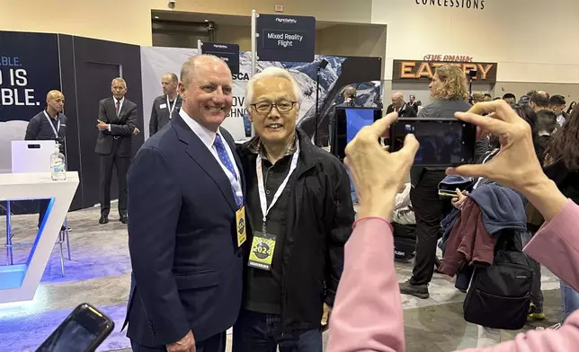 Berkshire Hathaway Vice Chairman Greg Abel poses for pictures with shareholders while touring the booths Berkshires companies set up, Friday, May 3, 2024, in Omaha, Neb. Abel will succeed Warren Buffett as CEO one day. (AP Photo/Josh Funk)