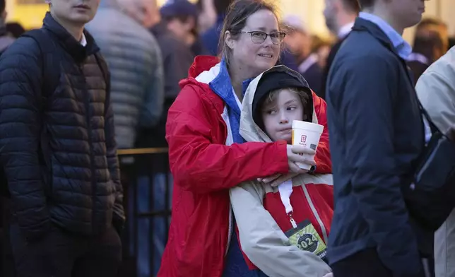 Amy Keady of Frederick, Maryland, holds her son, Ben, 11, as they wait in line outside the Berkshire Hathaway annual meeting on Saturday, May 4, 2024, in Omaha, Neb. (AP Photo/Rebecca S. Gratz)