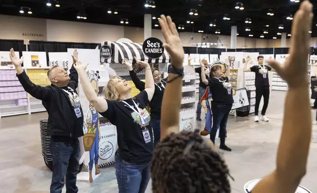 See's Candies associates, including Holly Pellicano of San Francisco, center, do yoga together before shareholders arrive for the Berkshire Hathaway annual meeting on Saturday, May 4, 2024, in Omaha, Neb. (AP Photo/Rebecca S. Gratz)