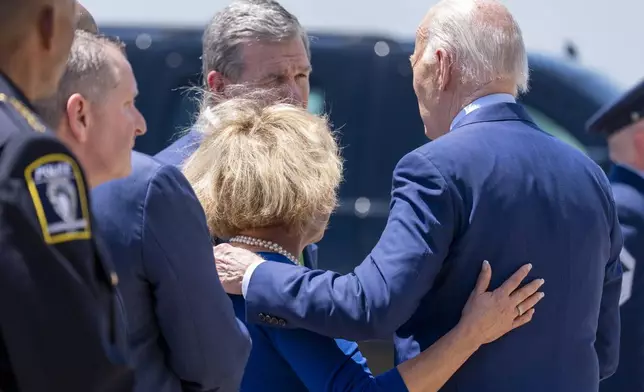 President Joe Biden, right, speaks with Charlotte, N.C., Mayor Vi Lyles, bottom center, and North Carolina Gov. Roy Cooper, top center, as he arrives on Air Force One at Charlotte Douglas International Airport, Thursday, May 2, 2024, in Charlotte, N.C. Biden is meeting with the families of law enforcement officers shot to death on the job. (AP Photo/Alex Brandon)