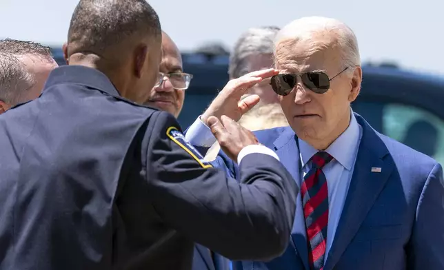 President Joe Biden salutes Charlotte-Mecklenburg Police Department Chief Johnny Jennings, as he arrives on Air Force One at Charlotte Douglas International Airport, Thursday, May 2, 2024, in Charlotte, N.C. Biden is meeting with the families of law enforcement officers shot to death on the job. (AP Photo/Alex Brandon)