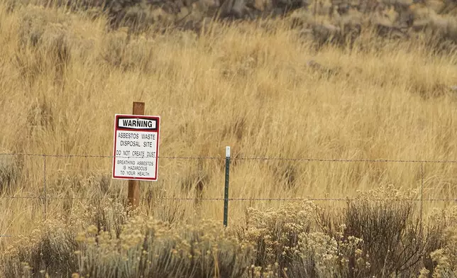 FILE - A warning sign points out the presence of asbestos at the North Ridge Estates superfund site just outside Klamath Falls, Ore., Nov. 19, 2015. The EPA has finalized a long-delayed ban on asbestos, a carcinogen that kills tens of thousands of Americans every year. (Kevin N. Hume/The Herald And News via AP)
