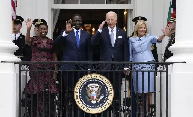 President Joe Biden salutes and first lady Jill Biden, Kenya's President William Ruto and Kenya's first lady Rachel Ruto, wave from the Blue Room Balcony during a State Arrival Ceremony on the South Lawn of the White House in Washington, Thursday, May 23, 2024. (AP Photo/Susan Walsh)
