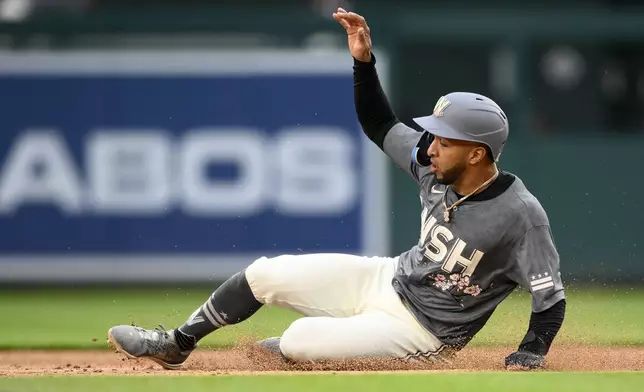 Washington Nationals' Eddie Rosario slides to steal second base during the second inning of a baseball game against the Toronto Blue Jays, Saturday, May 4, 2024, in Washington. (AP Photo/Nick Wass)