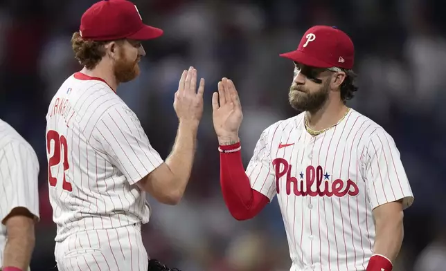 Philadelphia Phillies' Bryce Harper, right, and Spencer Turnbull celebrate after the Phillies won a baseball game against the Toronto Blue Jays, Tuesday, May 7, 2024, in Philadelphia. (AP Photo/Matt Slocum)