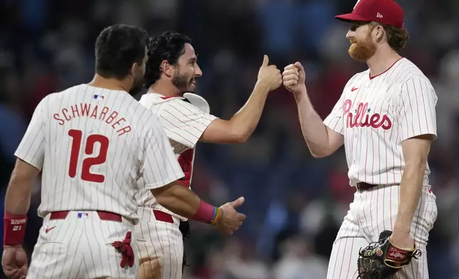 Philadelphia Phillies' Spencer Turnbull, from right, Garrett Stubbs and Kyle Schwarber celebrate after the Phillies won a baseball game against the Toronto Blue Jays, Tuesday, May 7, 2024, in Philadelphia. (AP Photo/Matt Slocum)