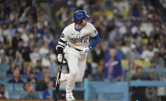 Los Angeles Dodgers designated hitter Shohei Ohtani singles during the tenth inning of a baseball game against the Atlanta Braves in Los Angeles, Friday, May 3, 2024. Chris Taylor scored. (AP Photo/Ashley Landis)
