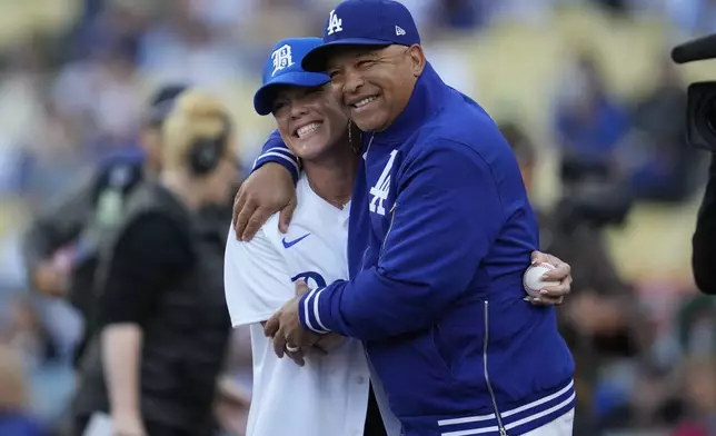 Pink, left, greets Los Angeles Dodgers manager Dave Roberts after throwing out the first pitch before a baseball game between the Atlanta Braves and the Los Angeles Dodgers in Los Angeles, Saturday, May 4, 2024. (AP Photo/Ashley Landis)