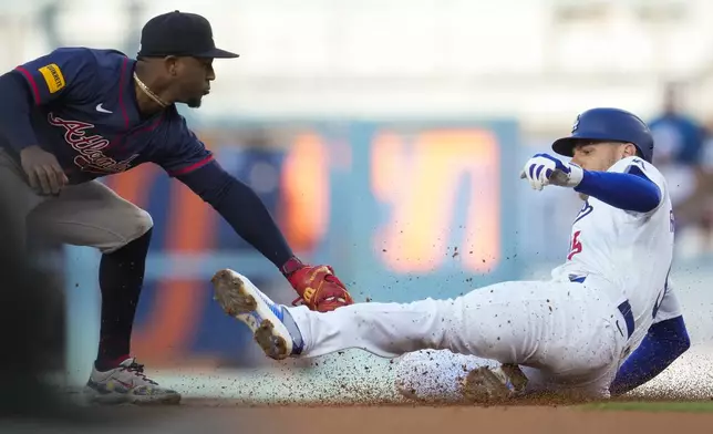 Los Angeles Dodgers' Freddie Freeman, right, is out at second with a tag by Atlanta Braves second baseman Ozzie Albies during the third inning of a baseball game in Los Angeles, Saturday, May 4, 2024. (AP Photo/Ashley Landis)