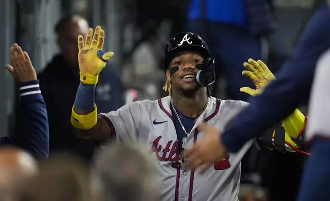 Atlanta Braves' Ronald Acuna Jr. returns to the dugout after hitting a home run during the eighth inning of a baseball game against the Los Angeles Dodgers in Los Angeles, Friday, May 3, 2024. (AP Photo/Ashley Landis)