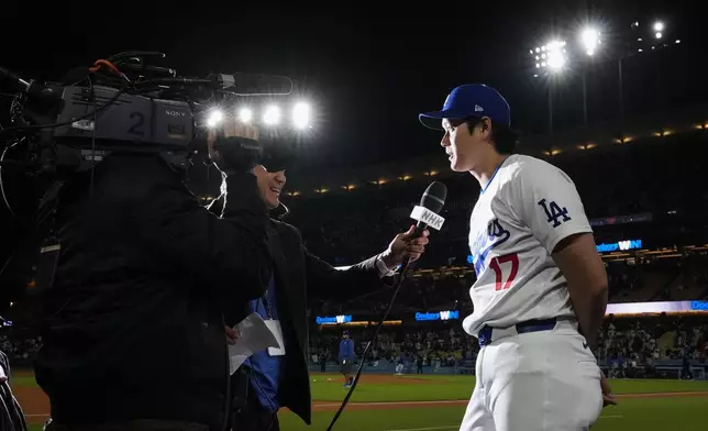 Los Angeles Dodgers designated hitter Shohei Ohtani (17) speaks to a reporter after an 11-2 win over the Atlanta Braves in a baseball game in Los Angeles, Saturday, May 4, 2024. (AP Photo/Ashley Landis)