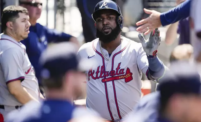 Atlanta Braves designated hitter Marcell Ozuna celebrates in the dugout after hitting a home run during the seventh inning of a baseball game against the Los Angeles Dodgers in Los Angeles, Sunday, May 5, 2024. (AP Photo/Ashley Landis)