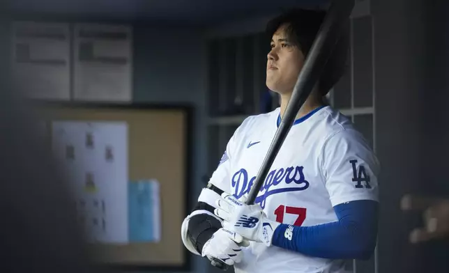 Los Angeles Dodgers designated hitter Shohei Ohtani stands in the dugout during the first inning of a baseball game against the Atlanta Braves in Los Angeles, Saturday, May 4, 2024. (AP Photo/Ashley Landis)