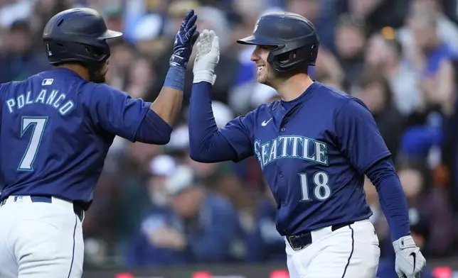 Seattle Mariners' Jorge Polanco is greeted by Mitch Garver (18) after Polanco hit a two-run home run against the Atlanta Braves during the third inning of a baseball game Tuesday, April 30, 2024, in Seattle. (AP Photo/Lindsey Wasson)