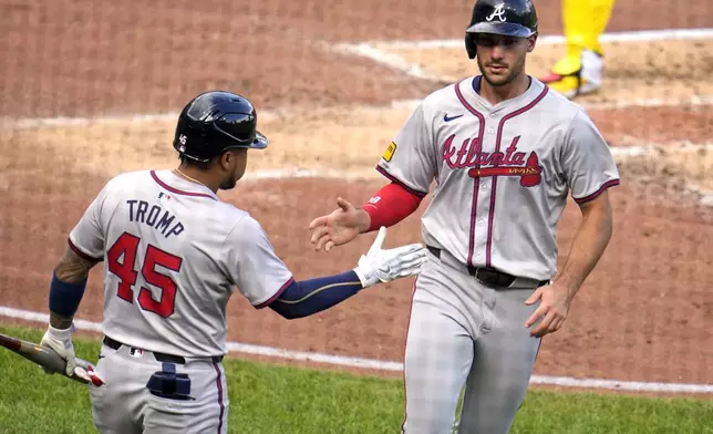 Atlanta Braves' Matt Olson, right, is greeted by Chadwick Tromp after scoring on a single by Jarred Kelenic off Pittsburgh Pirates starting pitcher Mitch Keller during the fourth inning of a baseball game in Pittsburgh, Saturday, May 25, 2024. (AP Photo/Gene J. Puskar)