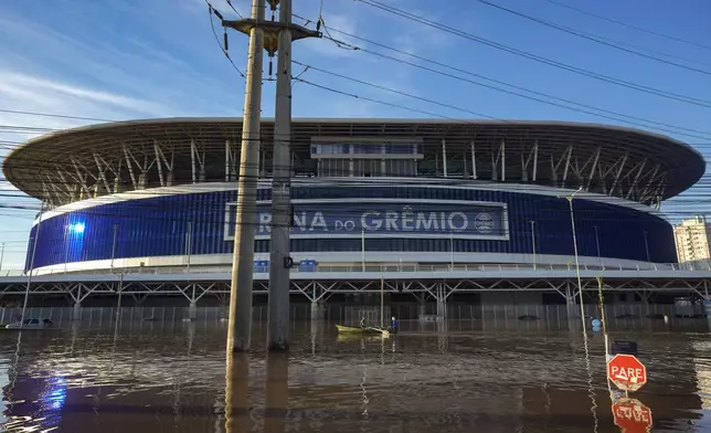 Residents row past the Gremio Arena surrounded by flood waters from heavy rains, in Porto Alegre, Rio Grande do Sul state, Brazil, Thursday, May 9, 2024. (AP Photo/Andre Penner)