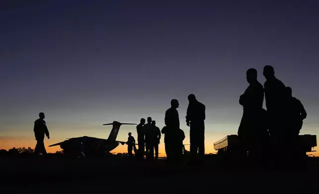 Military move through the yard preparing donations for humanitarian aid for victims and people who lost their homes from floods caused by heavy rains in the cities of the Rio Grande do Sul state, at the Air Base in Brasilia, Brazil, Saturday, May 11, 2024. (AP Photo/Eraldo Peres)