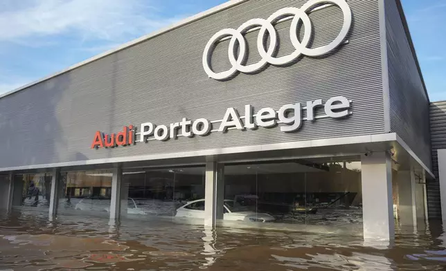 Vehicles sit partially submerged at an Audi car dealership, after heavy rains in Porto Alegre, Brazil, Tuesday, May 7, 2024. (AP Photo/Andre Penner)