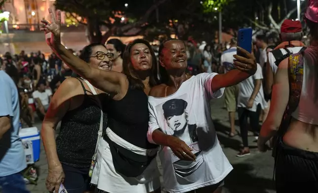 Fans take a selfie as they wait for the start of Madonna's last show of her The Celebration Tour, on Copacabana beach in Rio de Janeiro, Brazil, Saturday, May 4, 2024. (AP Photo/Silvia Izquierdo)