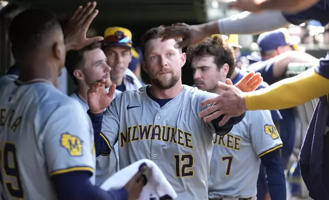 Milwaukee Brewers' Rhys Hoskins is greeted in the dugout after scoring on Oliver Dunn's triple in the seventh inning of a baseball game against the Chicago Cubs Saturday, May 4, 2024, in Chicago. (AP Photo/Charles Rex Arbogast)