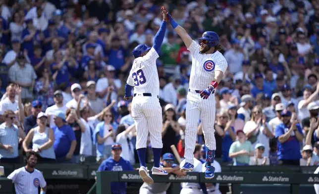 Chicago Cubs' Patrick Wisdom, right, celebrates his home run off Milwaukee Brewers relief pitcher Thyago Vieira with third base coach Willie Harris during the sixth inning of a baseball game Saturday, May 4, 2024, in Chicago. (AP Photo/Charles Rex Arbogast)