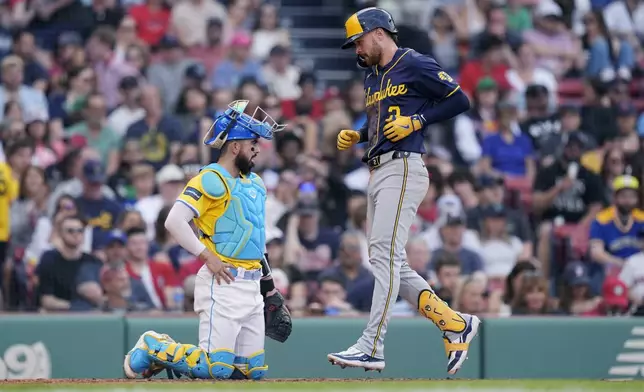 Milwaukee Brewers' Brice Turang, right, scores on his solo home run in front of Boston Red Sox catcher Connor Wong, left, during the eighth inning of a baseball game, Saturday, May 25, 2024, in Boston. (AP Photo/Michael Dwyer)