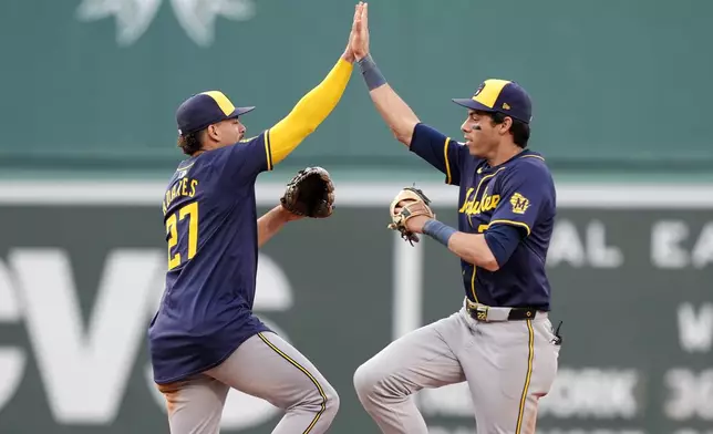 Milwaukee Brewers' Willy Adames (27) and Christian Yelich, right, celebrate after defeating the Boston Red Sox in a baseball game, Saturday, May 25, 2024, in Boston. (AP Photo/Michael Dwyer)