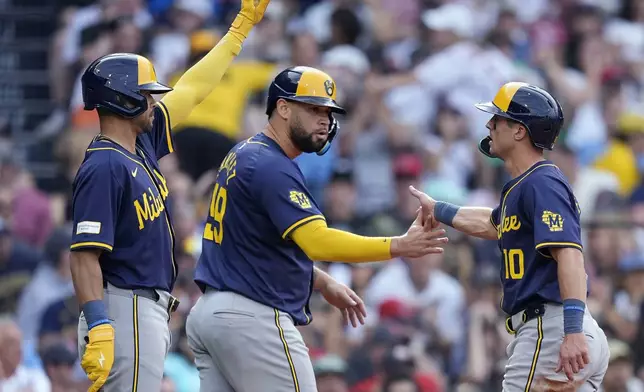 Milwaukee Brewers' Sal Frelick (10) and Gary Sánchez (99) celebrate with Blake Perkins after scoring on a two-run double by Joey Ortiz during the third inning of a baseball game against the Boston Red Sox, Saturday, May 25, 2024, in Boston. (AP Photo/Michael Dwyer)