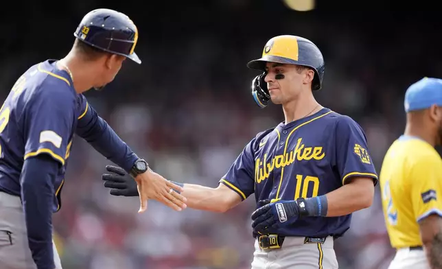 Milwaukee Brewers' Sal Frelick (10) celebrates his RBI single with first base coach Quintin Berry during the third inning of a baseball game against the Boston Red Sox, Saturday, May 25, 2024, in Boston. (AP Photo/Michael Dwyer)