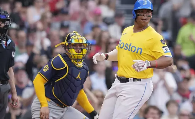 Boston Red Sox's Rafael Devers scores in front of Milwaukee Brewers catcher William Contreras on a double by Wilyer Abreu during the seventh inning of a baseball game Saturday, May 25, 2024, in Boston. (AP Photo/Michael Dwyer)