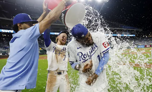 Kansas City Royals' Maikel Garcia, right, is doused by MJ Melendez, left, and Bobby Witt Jr. (7) at the end of a baseball game against the Milwaukee Brewers in Kansas City, Mo., Monday, May 6, 2024. (AP Photo/Colin E. Braley)