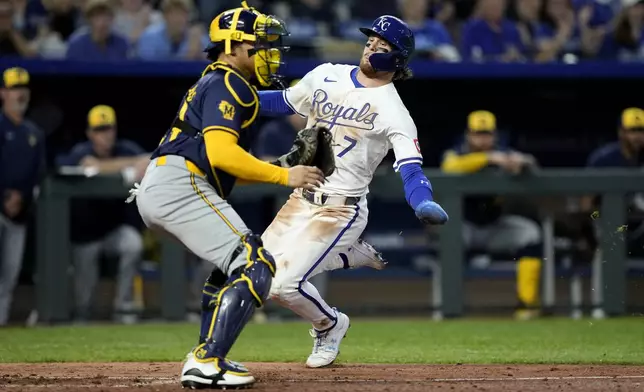 Kansas City Royals' Bobby Witt Jr. (7) slides home past Milwaukee Brewers catcher William Contreras to score on a single by Vinnie Pasquantino during the seventh inning of a baseball game Tuesday, May 7, 2024, in Kansas City, Mo. (AP Photo/Charlie Riedel)