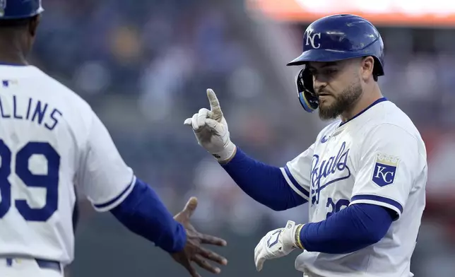 Kansas City Royals' Kyle Isbel, left, celebrates with first base coach Damon Hollins after hitting an RBI single during the fifth inning of a baseball game against the Milwaukee Brewers Tuesday, May 7, 2024, in Kansas City, Mo. (AP Photo/Charlie Riedel)