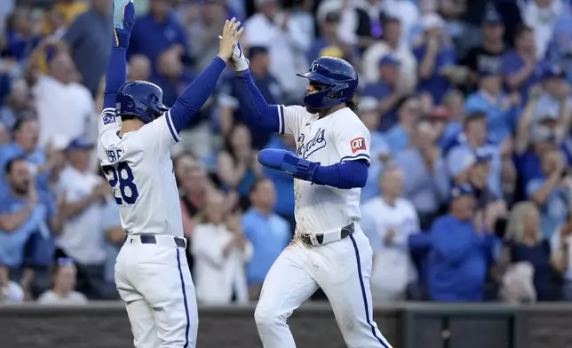 Kansas City Royals' Kyle Isbel (28) and Bobby Witt Jr. celebrate after scoring on a two-run double by Vinnie Pasquantino during the fifth inning of a baseball game against the Milwaukee Brewers Tuesday, May 7, 2024, in Kansas City, Mo. (AP Photo/Charlie Riedel)