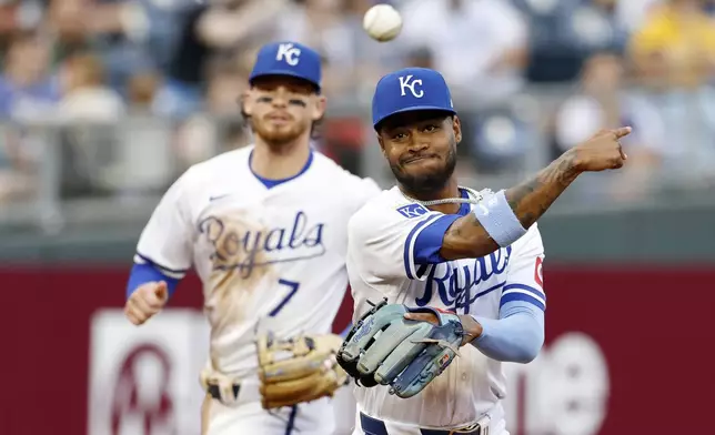 Kansas City Royals third baseman Maikel Garcia, right, throws to first base for an out after fielding a ground ball hit by Milwaukee Brewers' Joey Ortiz as shortstop Bobby Witt Jr. (7) watches during the third inning of a baseball game in Kansas City, Mo., Monday, May 6, 2024. (AP Photo/Colin E. Braley)