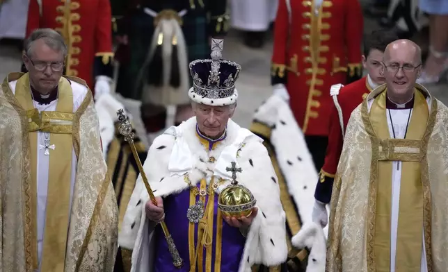 FILE - Britain's King Charles III, center, walks in the Coronation Procession after his coronation ceremony at Westminster Abbey in London, May 6, 2023. King Charles III’s decision to be open about his cancer diagnosis has helped the new monarch connect with the people of Britain and strengthened the monarchy in the year since his dazzling coronation at Westminster Abbey. (AP Photo/Kirsty Wigglesworth, Pool, File)