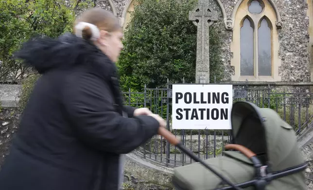 FILE - A woman pushes a buggy as she arrives to vote at a polling station in London, Thursday, May 2, 2024. Britain's governing Conservative Party is suffering heavy losses as local election results pour in Friday, piling pressure on Prime Minister Rishi Sunak ahead of a U.K. general election in which the main opposition Labour Party appears increasingly likely to return to power after 14 years. (AP Photo/Kin Cheung, File)