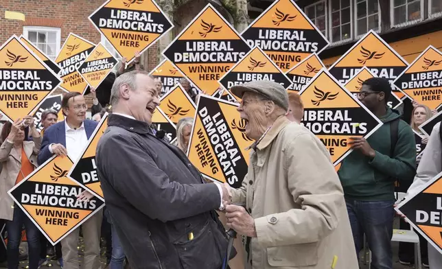 Britain's Liberal Democrat leader Sir Ed Davey, left, is congratulated by a local supporter in Winchester, England, following the results in local government elections, Friday May 3, 2024. (Stefan Rousseau/PA via AP)