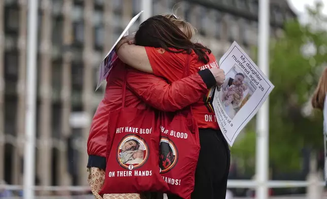Infected blood campaigners hug during a gathering at Parliament Square, ahead of the publication of the final report into the scandal, in London, Sunday, May 19, 2024. The final report of the U.K.’s infected blood inquiry will be published Monday, six years after it started its work. The inquiry heard evidence as to how thousands of people contracted HIV or hepatitis from transfusions of tainted blood and blood products in the 1970s and 1980s. (Aaron Chown/PA via AP)