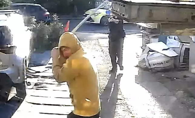 Handout footage from a doorbell camera of police officers tasering a sword-wielding man in Hainault, north east London, after a 14-year-old boy died after being stabbed following an attack on members of the public and two police officers, Tuesday April 30, 2024. Knife crimes are on the rise in England and Wales, and a string of deadly attacks in recent years has stoked public anxiety and led to calls for the government to do more. (PA via AP)