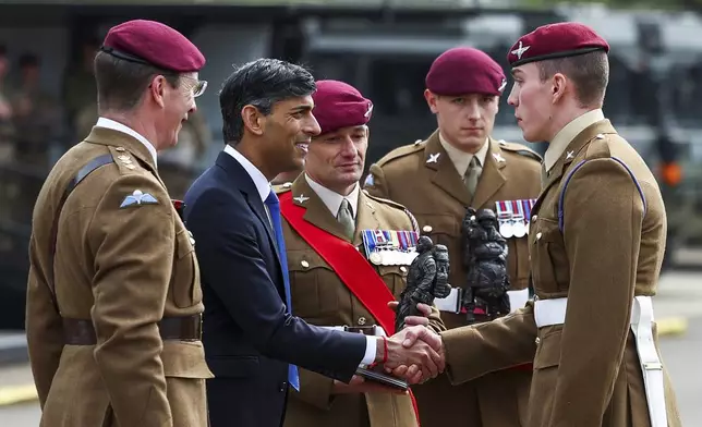 Britain's Prime Minister Rishi Sunak presents an award to a member of the Parachute Regiment as he visits the Helles Barracks at the Catterick Garrison, a military base in North Yorkshire, Britain, Friday, May 3, 2024. (Molly Darlington/Pool photo via AP)