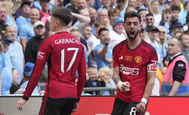 Manchester United's Alejandro Garnacho, left, celebrates after scoring his side's opening goal with his teammate Bruno Fernandes during the English FA Cup final soccer match between Manchester City and Manchester United at Wembley Stadium in London, Saturday, May 25, 2024. (AP Photo/Kin Cheung)