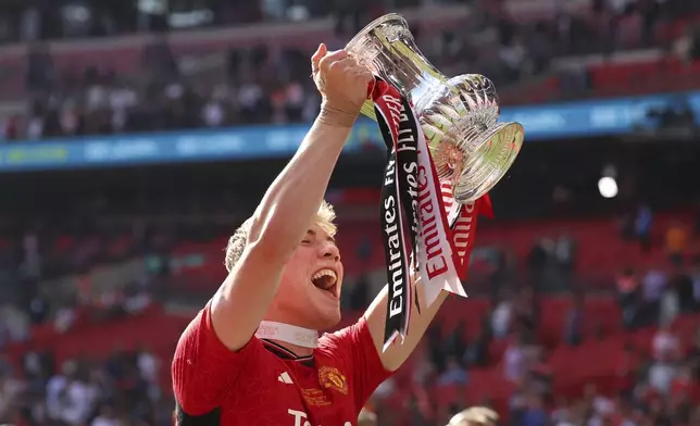 Manchester United's Rasmus Hojlund celebrates with the trophy after winning the English FA Cup final soccer match between Manchester City and Manchester United at Wembley Stadium in London, Saturday, May 25, 2024. (AP Photo/Ian Walton)