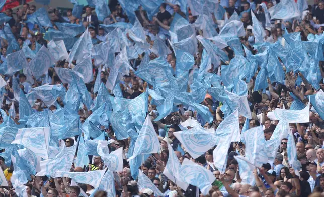 Manchester City fans wave flags ahead of the English FA Cup final soccer match between Manchester City and Manchester United at Wembley Stadium in London, Saturday, May 25, 2024. (AP Photo/Ian Walton)