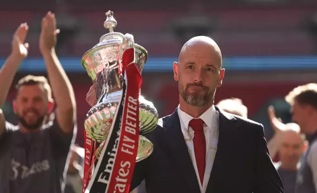 Manchester United's head coach Erik ten Hag celebrates with the trophy after winning the English FA Cup final soccer match between Manchester City and Manchester United at Wembley Stadium in London, Saturday, May 25, 2024. (AP Photo/Ian Walton)