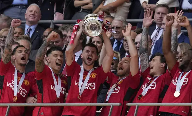 Manchester United's Mason Mount raises the trophy after his team won the English FA Cup final soccer match between Manchester City and Manchester United at Wembley Stadium in London, Saturday, May 25, 2024. Manchester United won 2-1. (AP Photo/Kin Cheung)