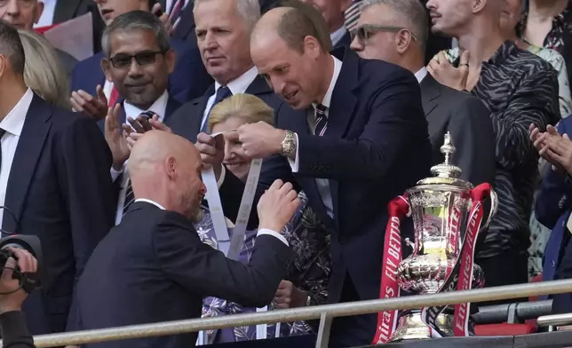 Manchester United's head coach Erik ten Hag, left, receives his winner's medal from Britain's Prince William, after his team won the English FA Cup final soccer match between Manchester City and Manchester United at Wembley Stadium in London, Saturday, May 25, 2024. Manchester United won 2-1. (AP Photo/Kin Cheung)